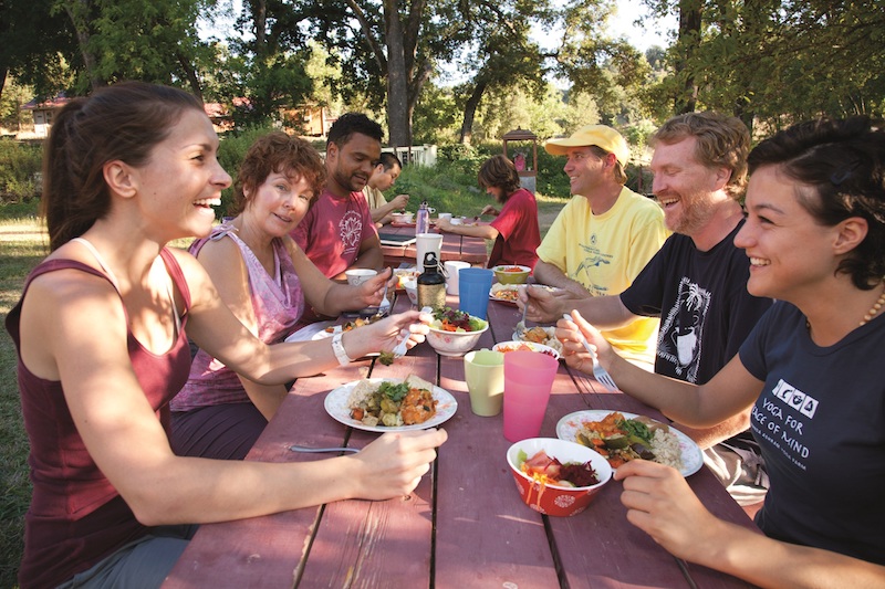Yoga Vacation guests talk and laugh while eating a delicious meal.