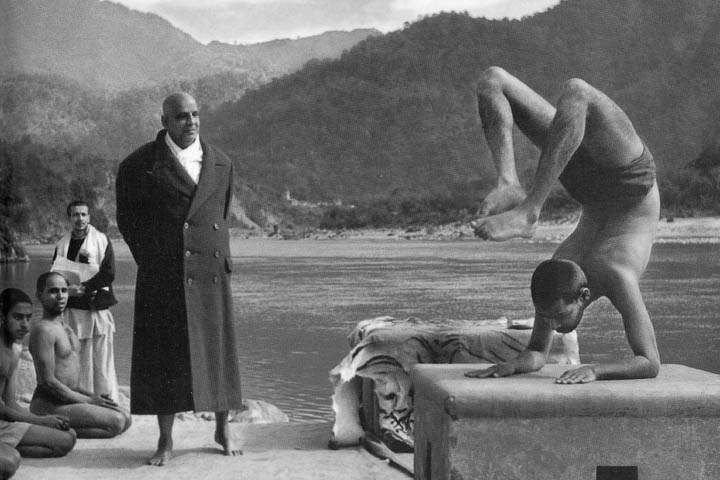 Master Sivananda watches a young Swami Vishnu perform the scorpion posutre.