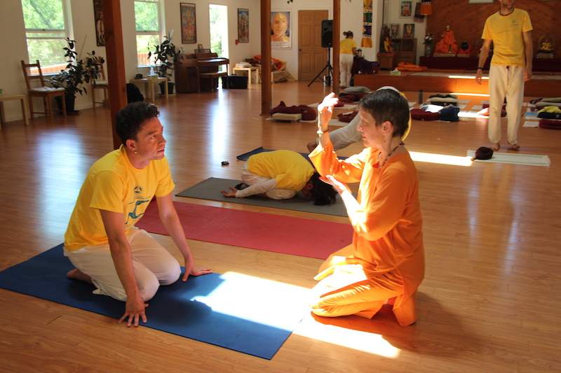 Yoga teacher helping student learn headstand
