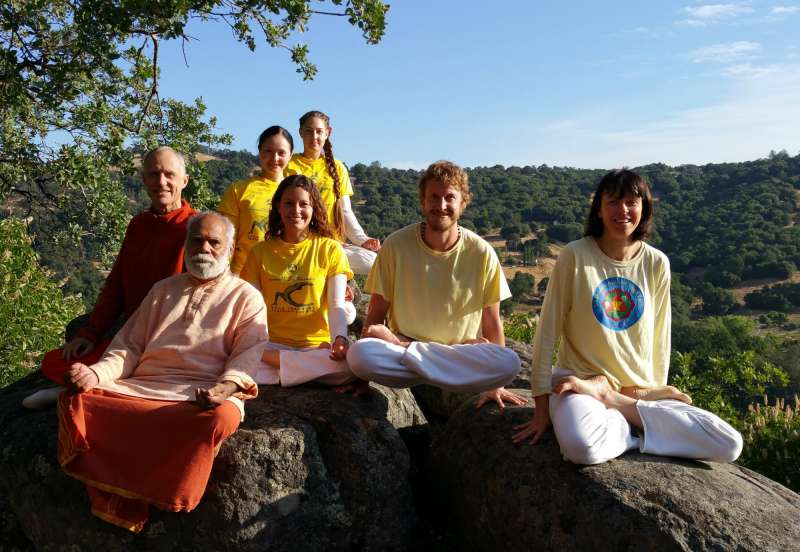 Group of teachers and swamis sitting on rock at siva hill.