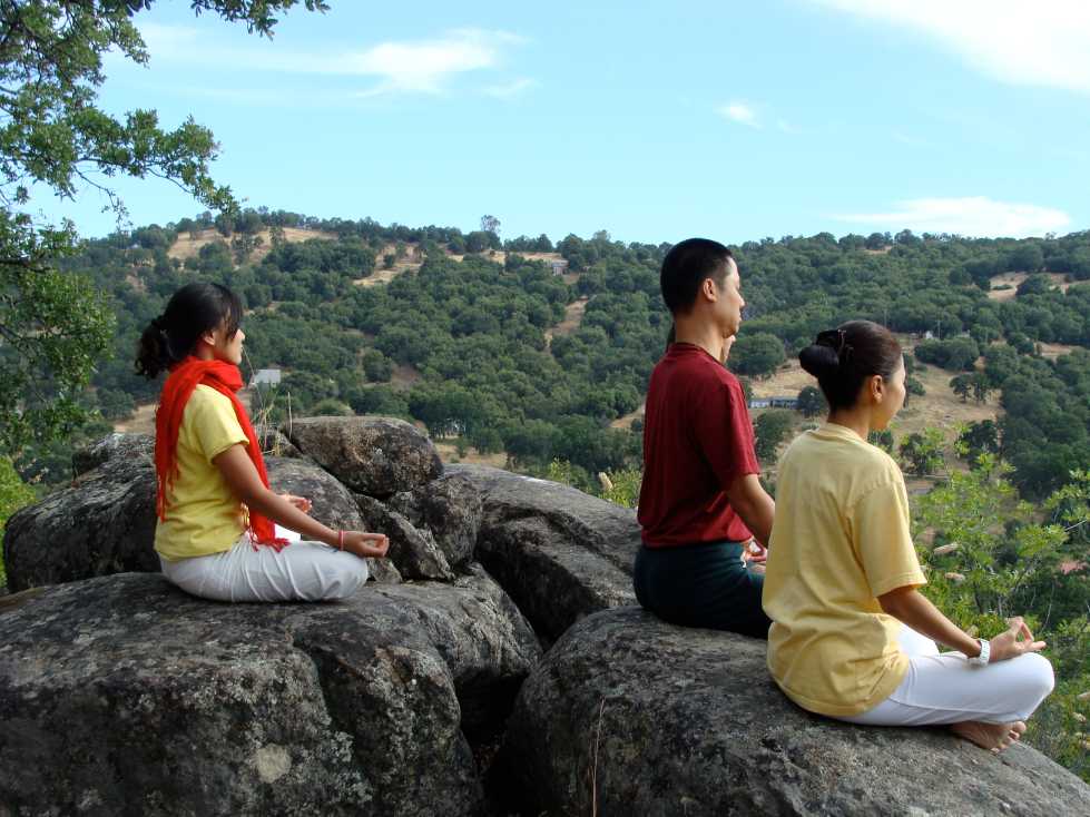 Students sit and meditate on top of rock