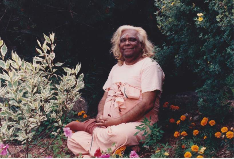 Swami Vishnu smiling with flowers and plants around