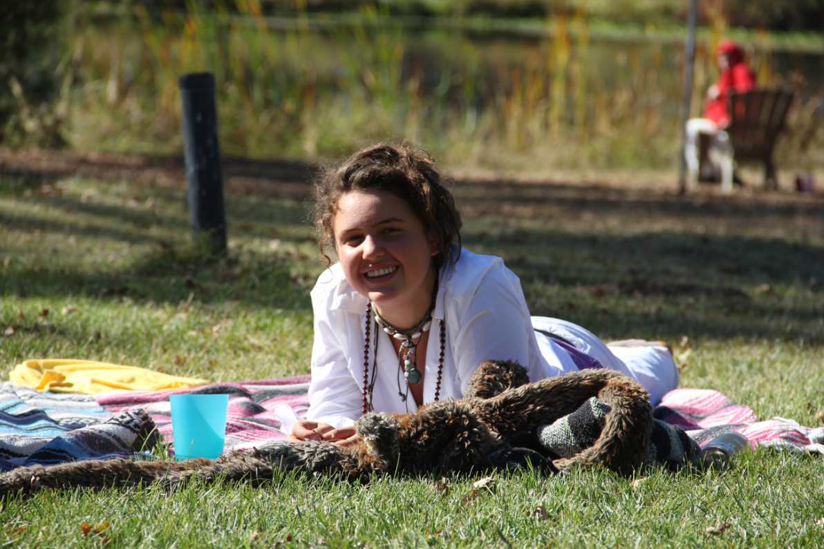 A girl lies down in the grass smiling and happy