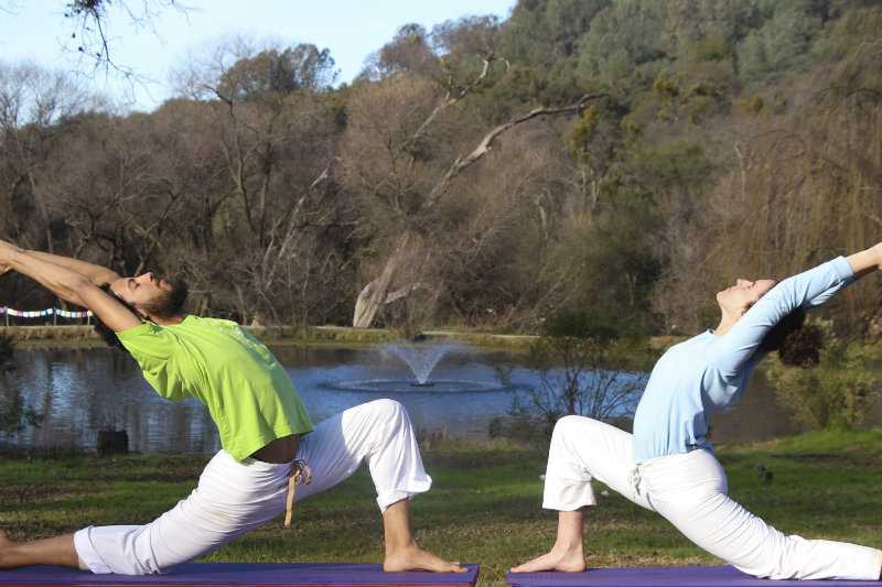 Two students practice the crescent moon pose.