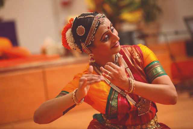 Indian dancer with traditional dress and hand gesture of holding flute