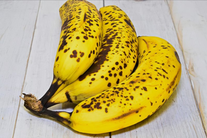 Three ripe bananas on a table.